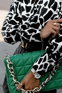 Détail d'un chemisier à manches longues avec imprimé girafe noir et blanc et boutons