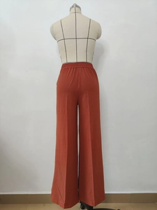 Detail view of high-waisted wide-leg pants showing pleated texture and elastic waistband
