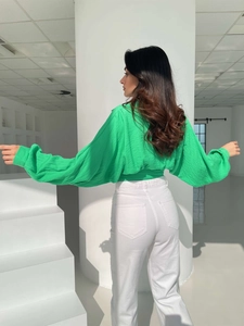 Rear view of bright green puff sleeve cropped blouse with textured fabric and tie-back detail