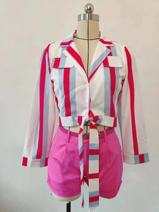 Détail d'une chemise courte rayée avec nœud et d'un short rose avec ceinture