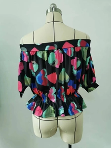 Detail of off-shoulder blouse with vibrant abstract painting print and elastic hem