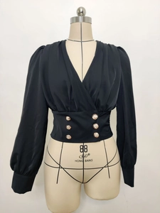 Detail of black V-neck puff sleeve blouse with decorative gold buttons on the waist