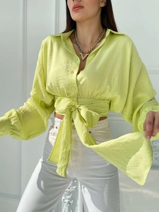 Detail of lime green cropped shirt featuring crinkle texture fabric and waist tie detail