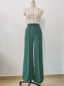 Detail of green high-waisted wide-leg trousers with pleated texture and button closure