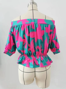 Detail of off-shoulder floral blouse showing smocked neckline and vibrant turquoise print
