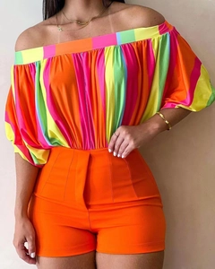 Detail of off-shoulder puff sleeve top in colorful stripes with high waist orange shorts