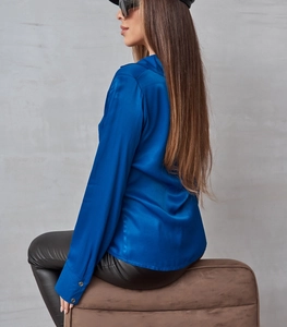 Dettaglio del tessuto in raso blu e degli eleganti bottoni argentati sui polsini della camicia