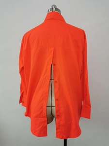 Detail view of the back split with buttons on the orange long-sleeved shirt