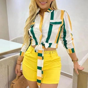 Détail d'une chemise rayée nouée devant et d'un short jaune à taille haute assorti