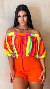 Close-up of vibrant neon striped off-shoulder top and high-waisted orange shorts