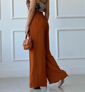Detail view of high-waist wide-leg trousers in caramel with elastic waist and drape fabric