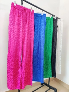 Close-up of leopard print satin fabric and elastic drawstring waist on women wide leg pants