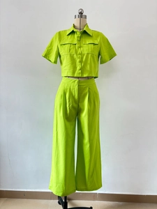 Détail de l'ensemble vert fluo avec chemise à manches courtes et pantalon large fluide