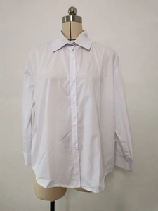 Detailed view of women's white long-sleeve shirt with classic collar and button-up front