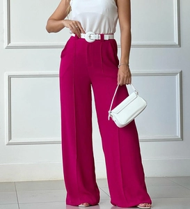 Detail of high-waisted fuchsia wide-leg trousers featuring a bold white round buckle belt