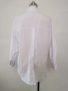Detail of white long sleeve shirt featuring a creative vertical button-down back design