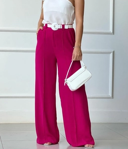 Detail of rose pink high-waisted wide-leg trousers with vertical pleats and white belt