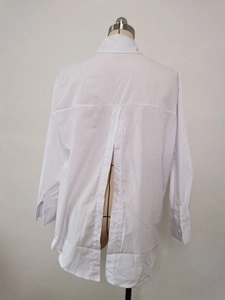 Detailed back view of a white shirt featuring a button-down seam and high slit design