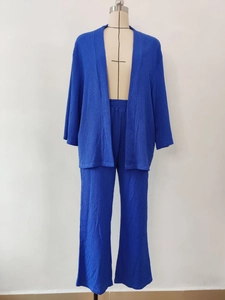 Dettaglio di un completo due pezzi blu scuro con tessuto plissettato e pantaloni larghi