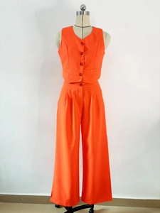 Detail of bright orange two-piece set featuring a V-neck vest and wide-leg trousers