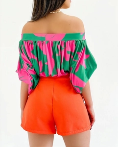 Rear view of floral off-shoulder top with bright orange high-waist shorts set