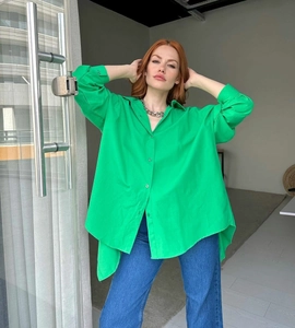 Detail of vibrant green oversized long sleeve shirt with irregular hem and side slits