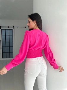 Detail view of pink puff sleeve top featuring elastic waist and golden cuff buttons