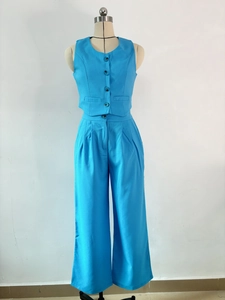 Detail of royal blue two-piece set featuring button-up vest and high-waisted wide-leg trousers