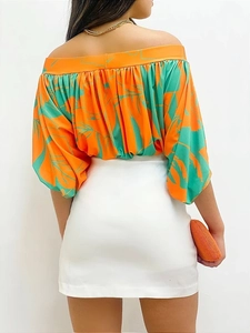 Detail view of woman in off-shoulder floral puff sleeve top with white mini skirt
