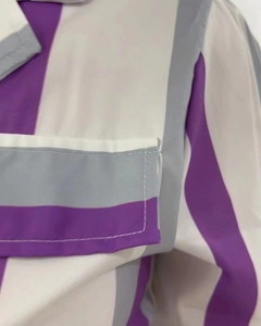 Gros plan du tissu rayé violet et gris avec détails de couture de poche sur la chemise