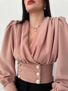 Detail of V-neck puff sleeve blouse with pink chiffon fabric and gold buttoned waist