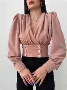 Detail of V-neck shirt featuring double-breasted gold buttons and pleated puff sleeves