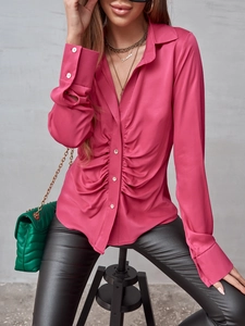 Dettaglio della camicia in raso rosa con arricciatura in vita e bottoni perlati fini