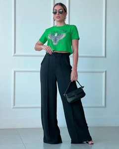 Detail of high-waisted black wide-leg trousers paired with a green graphic crop T-shirt