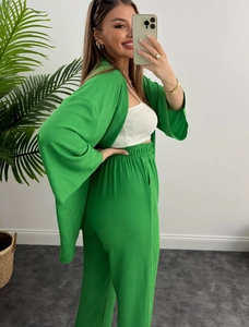 Dettaglio del tessuto stropicciato di un completo casual verde due pezzi con elastico