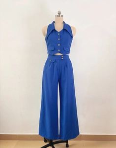 Detail view of bright blue halter top with buttons and matching high-waisted wide-leg trousers