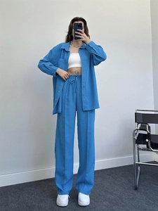 Close-up of blue pleated wide-leg pants with elastic drawstring waist for women