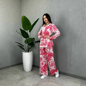 Detail of floral print suit set featuring tropical palm pattern and waist belt tie