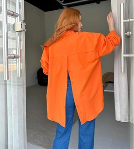Detail of orange oversized shirt featuring a unique vertical buttoned slit design on back