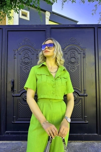 Détail du tissu en lin texturé vert fluo sur la chemise courte et le pantalon large