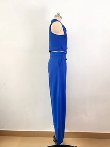 Detail of blue two-piece set featuring tailored vest with flap pockets and high-waist pants