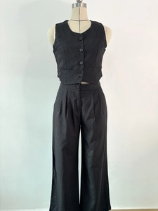 Detail of black two-piece set featuring sleeveless vest and high-waisted wide-leg trousers