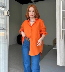 Detail of oversized orange long-sleeve shirt with cotton-linen texture and buttons