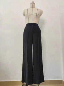 Detail of high waist wide leg black trousers with front seam on a display mannequin