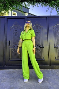Détail d'un ensemble néon vert deux pièces avec crop top court et pantalon large chic