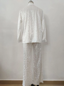 Detail of white satin pajama set with leopard jacquard texture on long-sleeve shirt and pants