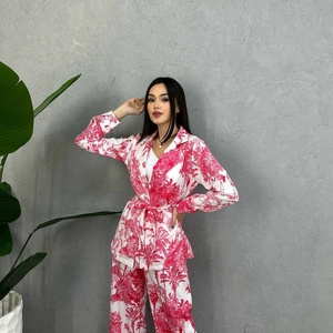 Detail of floral print suit with waist tie and tropical palm leaf patterns on white fabric