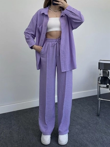 Detail of lavender textured fabric on loose long-sleeved shirt and wide-leg trousers set