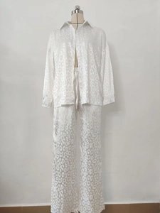 Detail of white leopard jacquard satin fabric on long sleeve shirt and trousers set