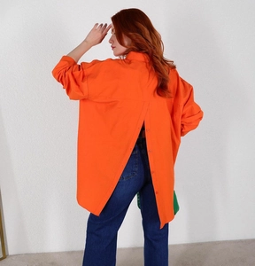 Detail of orange long sleeve shirt featuring a unique button back split design with jeans